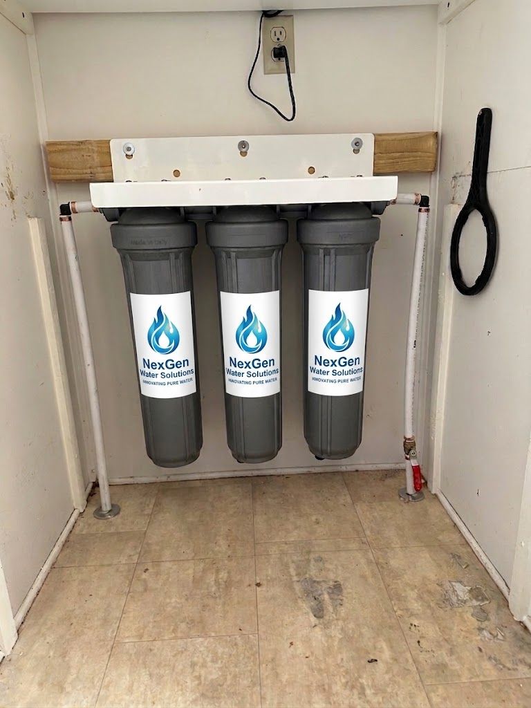 Three NexGen filter housings mounted side by side on a board, plumbed in series and feeding a single supply line.
